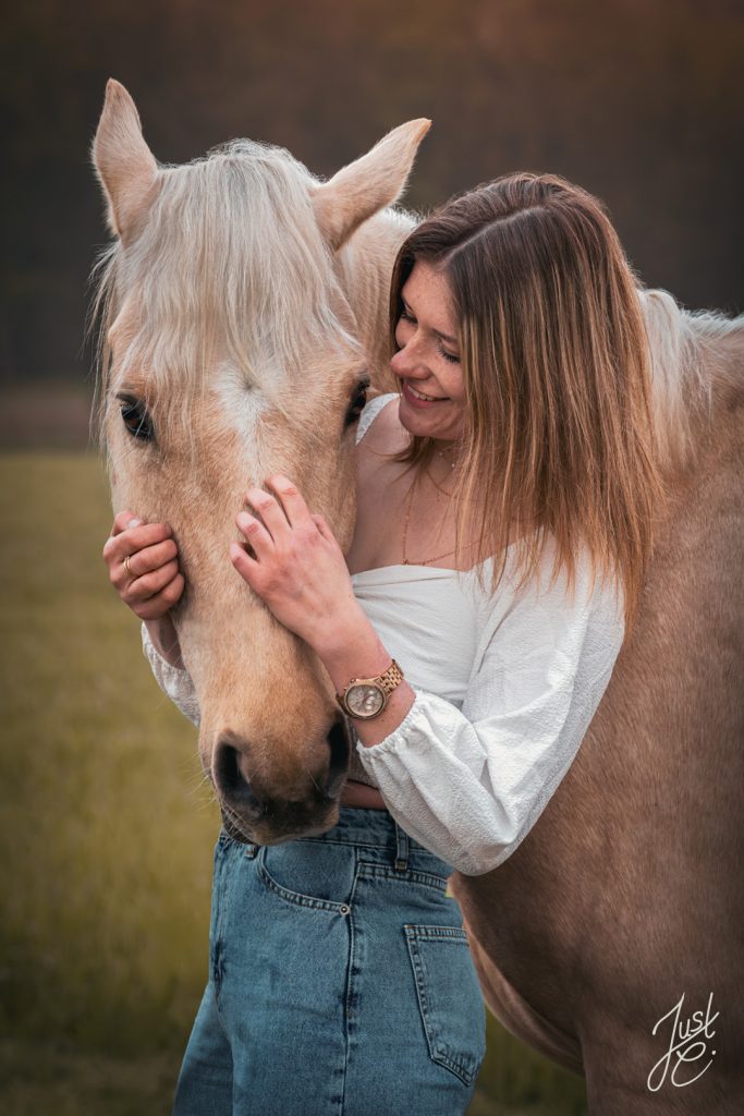 Emotionales Pferdeportrait von einem deutschen Reitpony und ihre Besitzerin bei einem Shooting im Freien
